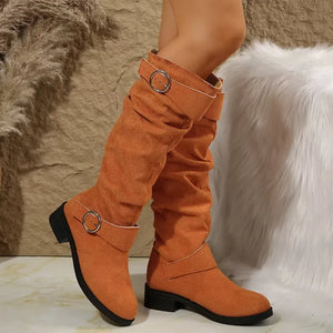 Slouchy knee-high boots in terracotta with buckle detail and flat heel.