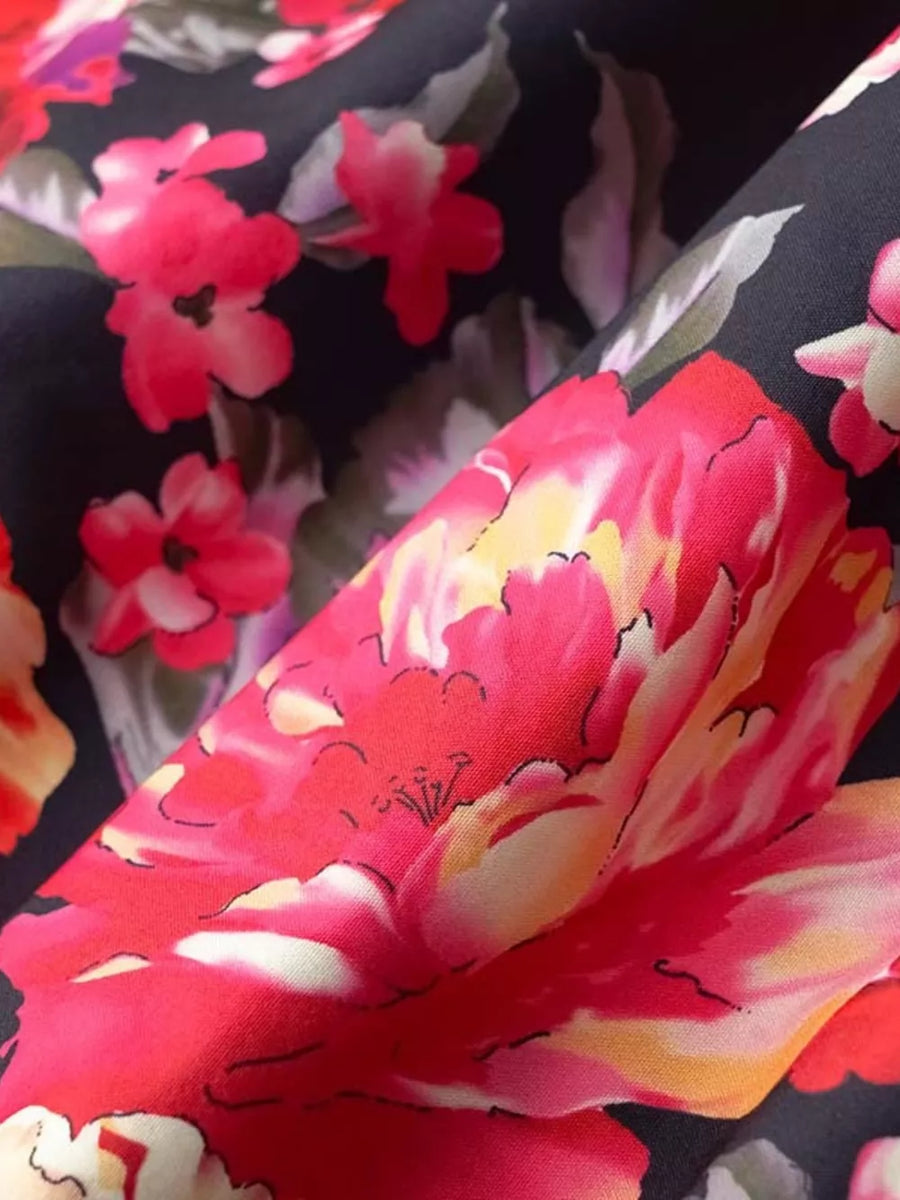 Black mini dress with vibrant floral print and ruffle hem detail