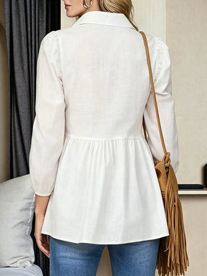 White peplum blouse with 3/4 puff sleeves and a notched collar, styled with jeans.