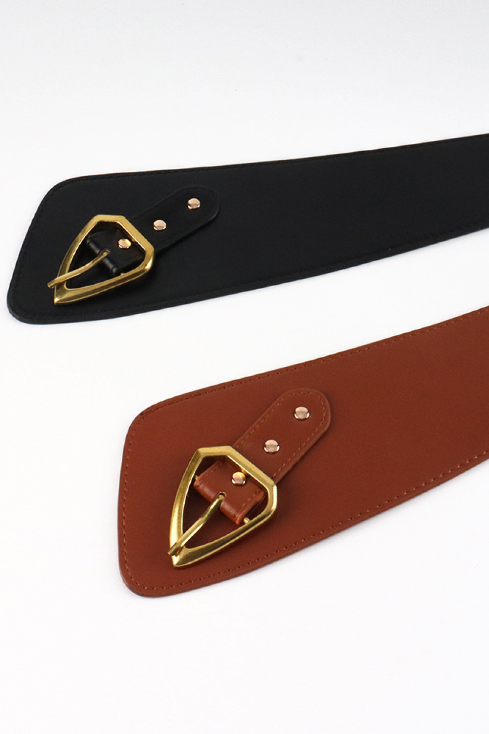 Sculpted leather waist belts in black and brown with gold buckles.