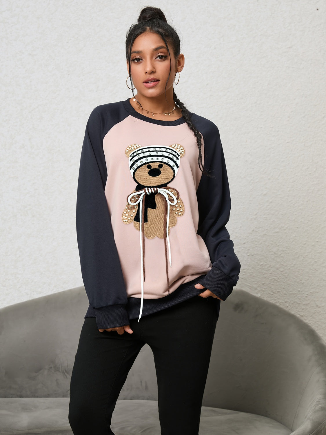 Blush pink raglan sweatshirt with teddy bear appliqué and drawstring detail.
