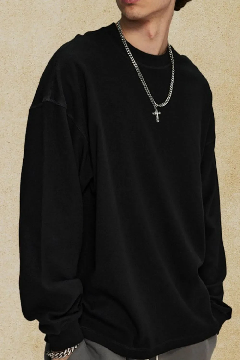 Black oversized drop shoulder crewneck sweatshirt with crew neckline and long sleeves.