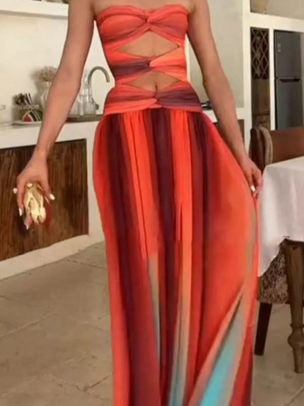 Strapless ombre maxi dress with twisted bodice cutouts and flowing skirt.