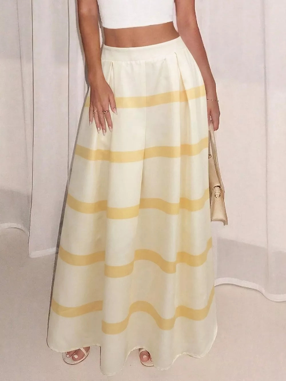 Flowy maxi skirt with yellow stripes and pockets, pleated waist, white crop top.