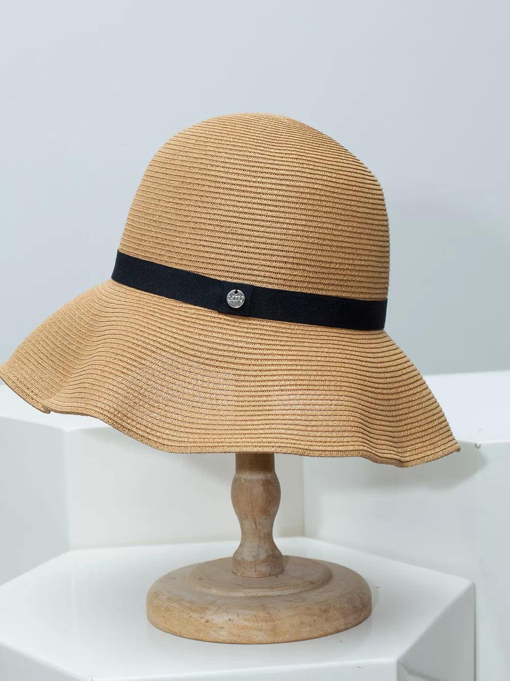 Charming straw sun hat in khaki with elegant black ribbon and silver charm detail.