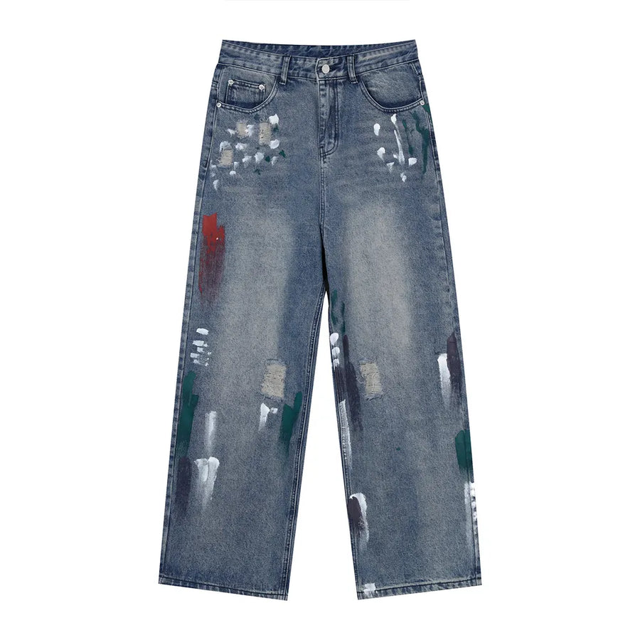 Baggy jeans in medium wash denim with artistic paint splatters and distressed details.