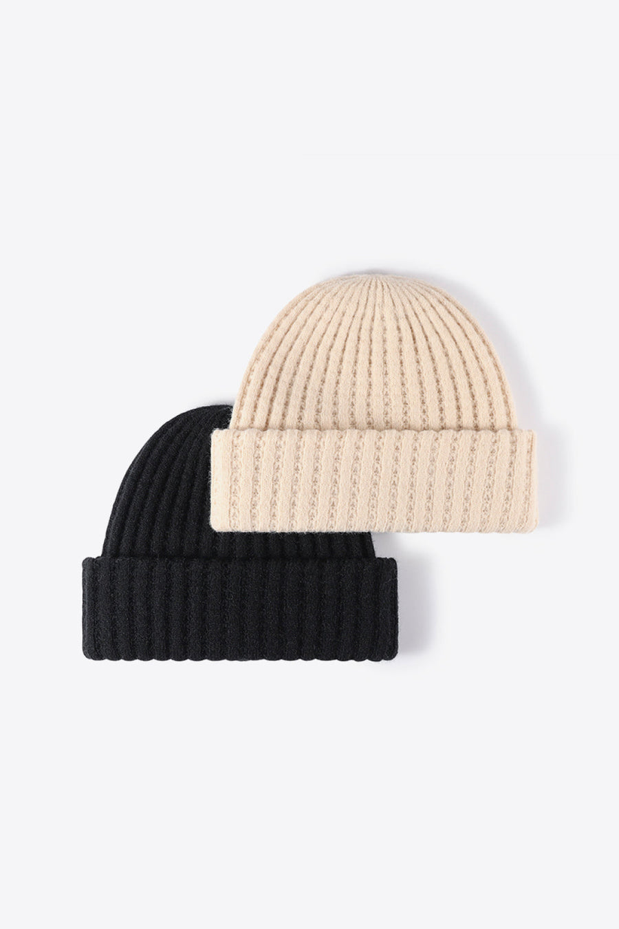 Textured ribbed knit beanies in black and beige with cuffed hems.