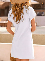 White waffle knit dress with short sleeves and lace detail, styled with a straw hat.