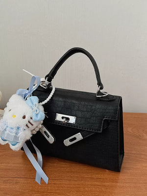Black croc-embossed mini crossbody bag with Hello Kitty charm and pearl accents.