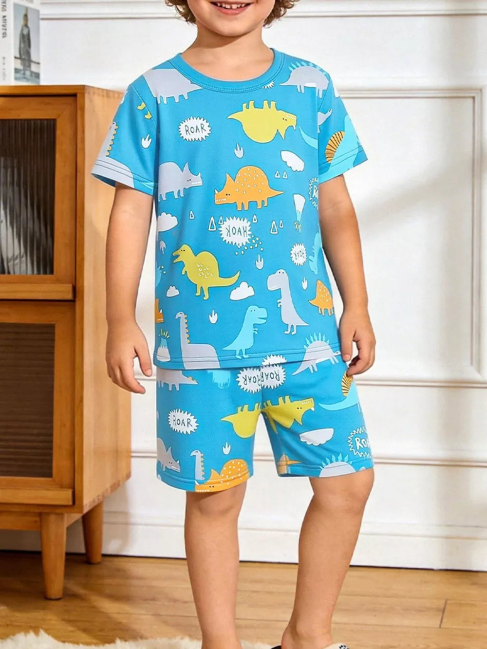 Blue dinosaur print pajama set for kids with short sleeves and shorts.