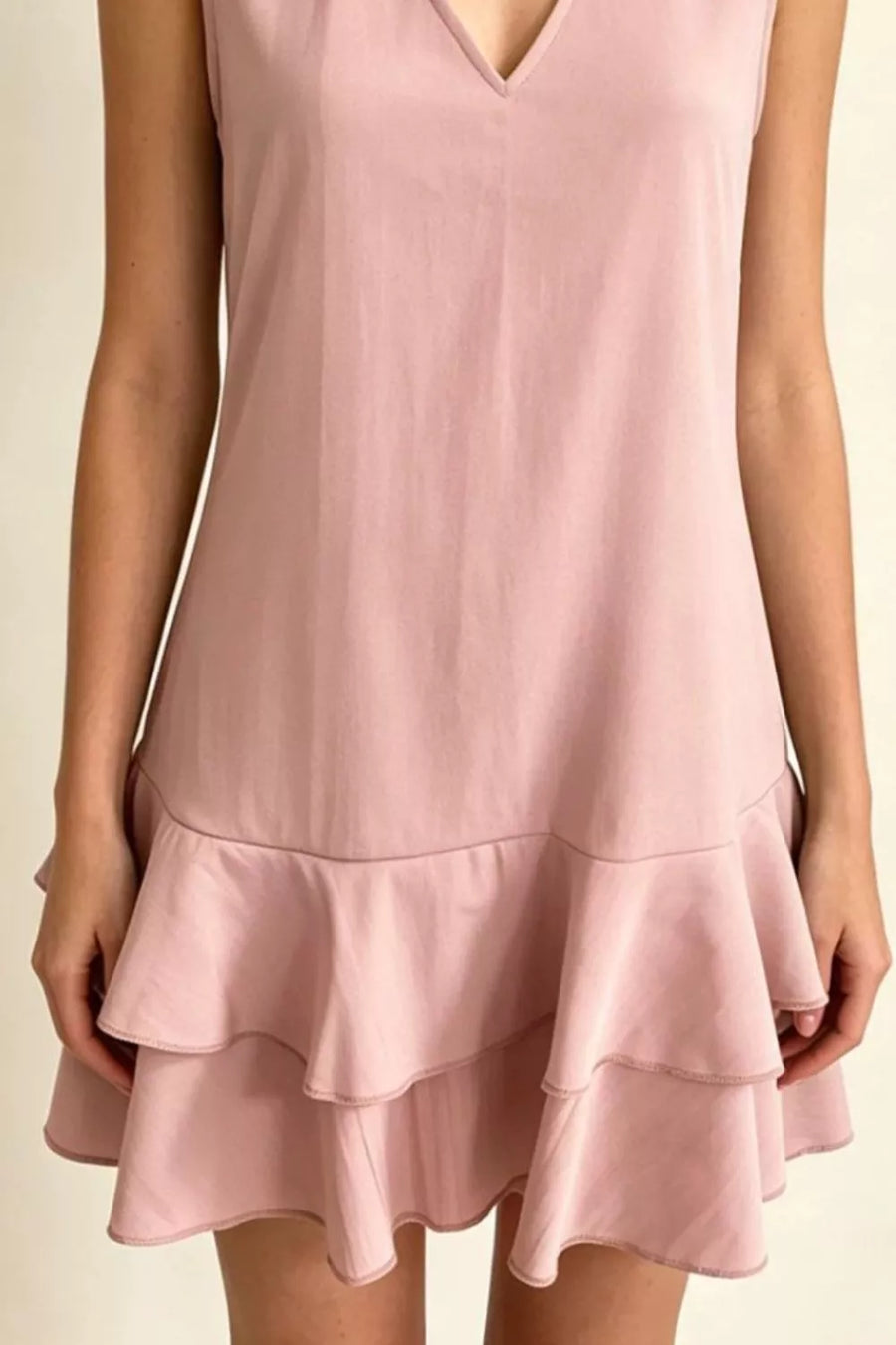 Dusty pink polyester mini dress with V-neck and tiered ruffle hem.