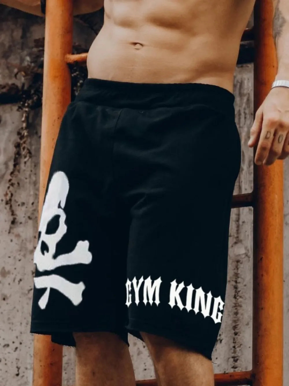 Black jogger shorts with white skull and crossbones graphic and Gym King text.