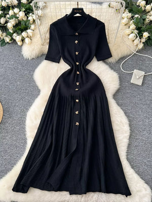Black knit Peter Pan collar dress with gold buttons and short sleeves.