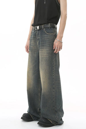 Faded wash denim palazzo trousers in a medium blue with a wide leg and distressed details.