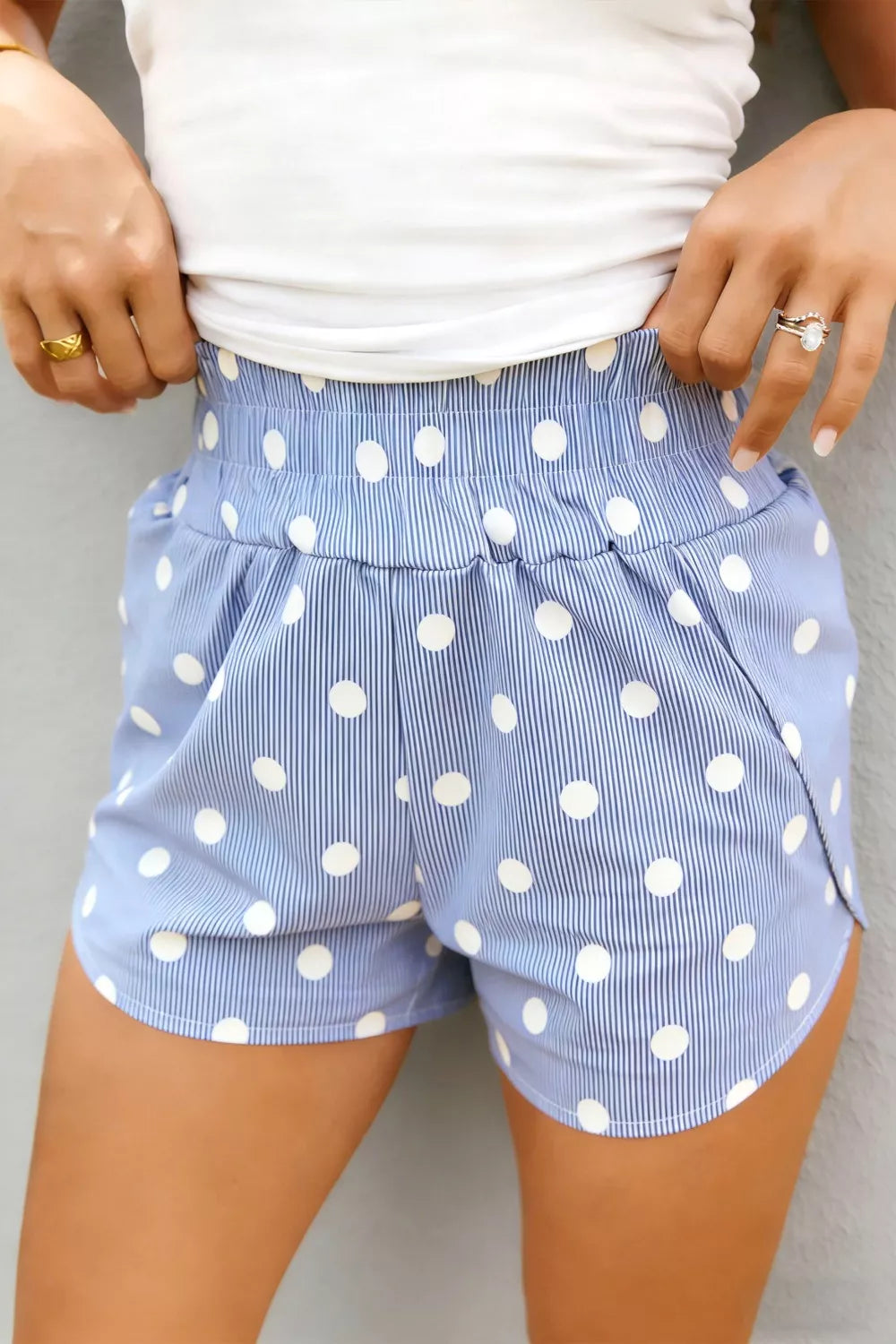 Blue polka dot and stripe print shorts with elastic waist and pockets.