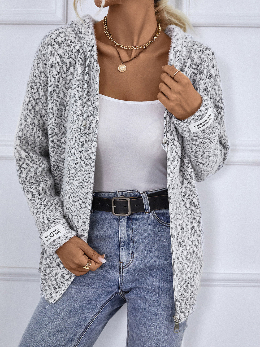 Textured knit zip-up cardigan in charcoal with a subtle geometric pattern and logo detail on the sleeve.