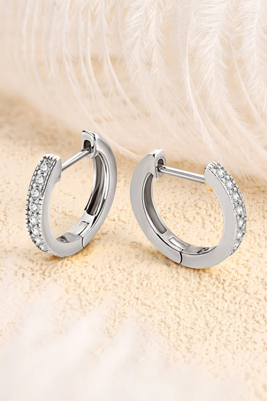 Silver pave-set huggie hoop earrings with sparkling stones.