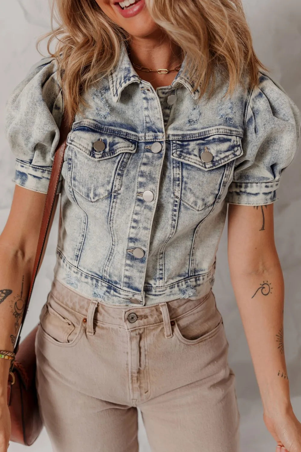 Cropped denim bolero jacket with puff sleeves and distressed details in medium wash.
