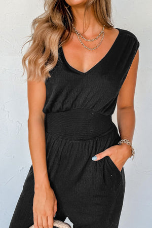 Black textured ribbed waist jumpsuit with V-neck and cap sleeves.