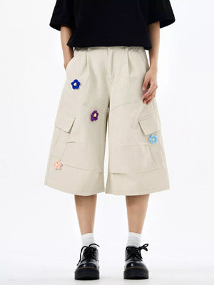 Tan cotton cargo shorts with floral appliques and wide legs.