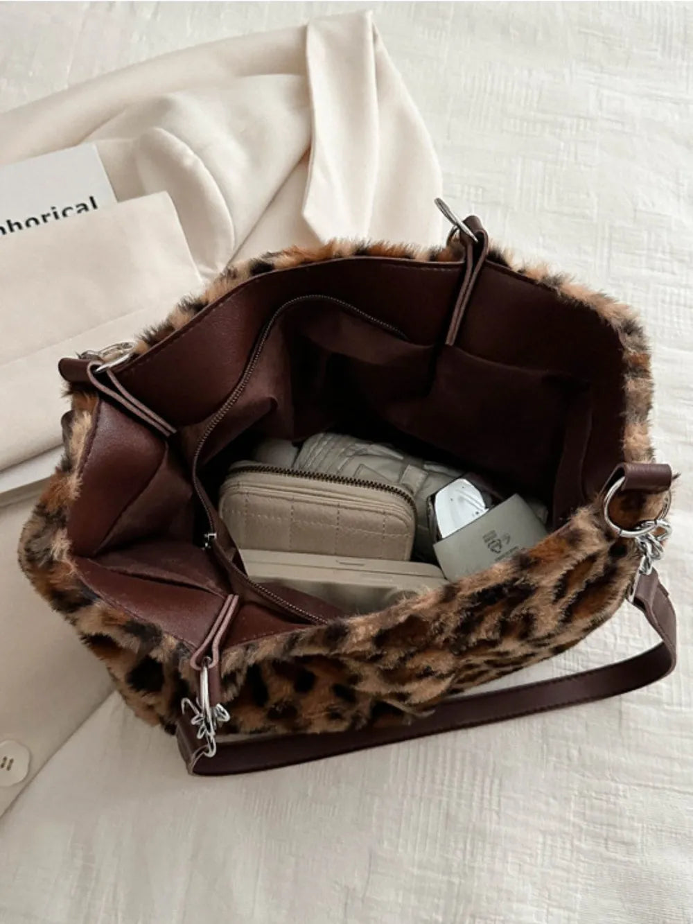 Leopard print faux fur tote bag with brown leatherette trim and chain handle detail.