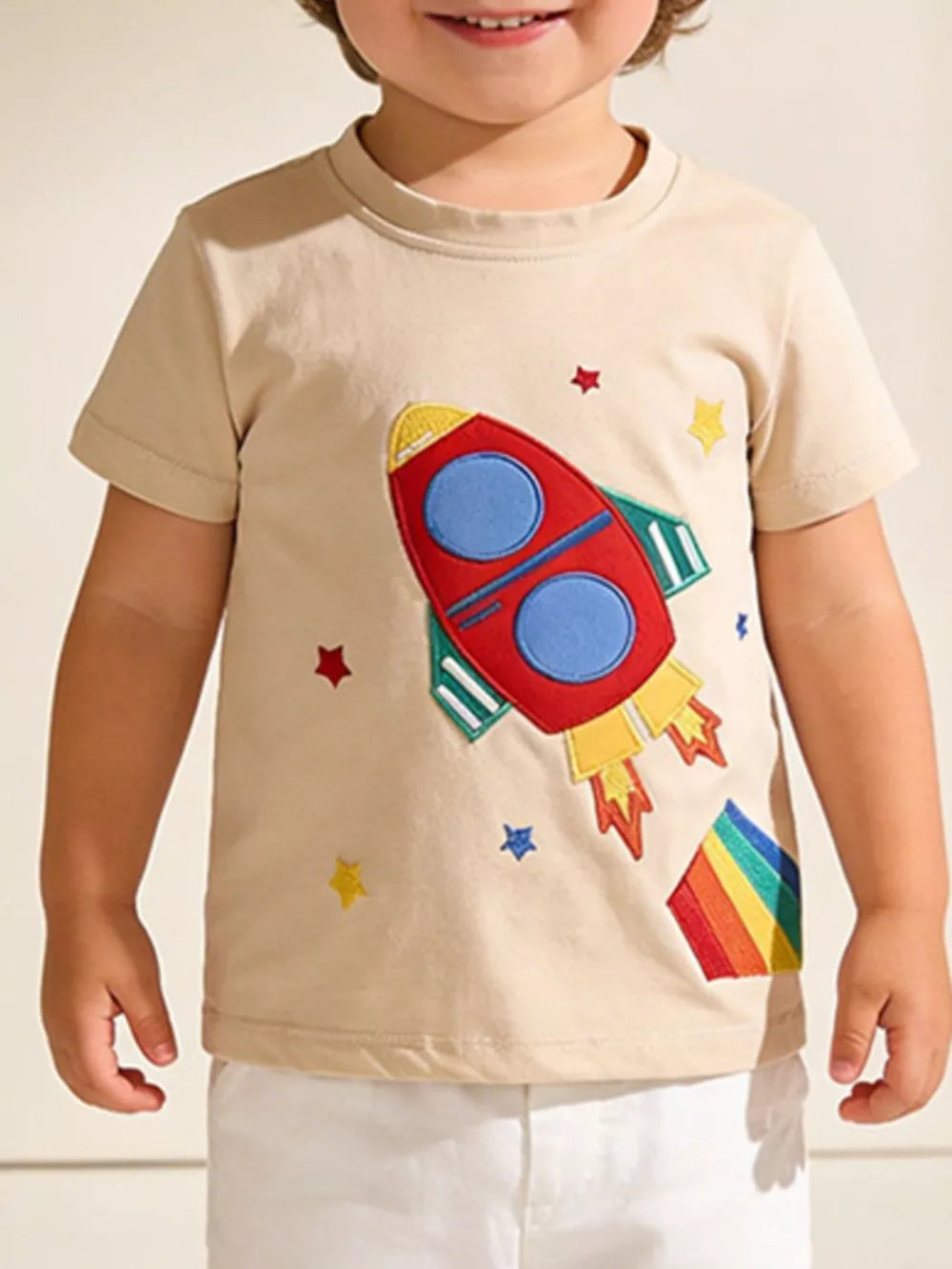 Toddler beige cotton t-shirt with rocket and rainbow embroidery.