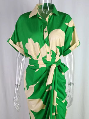 Green abstract print belted shirt dress with short sleeves and collared neckline.