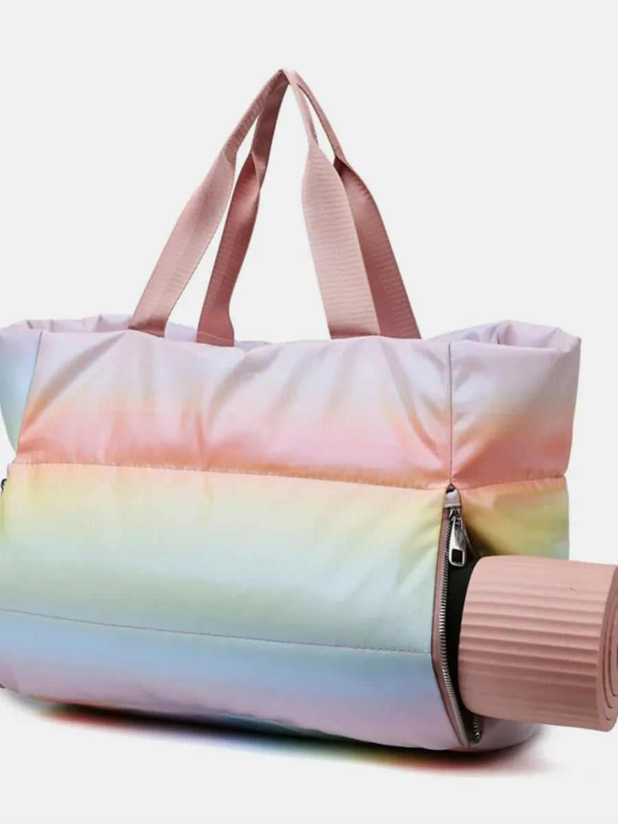 Prismatic padded tote bag with side zip and pink straps, holding a rolled yoga mat.