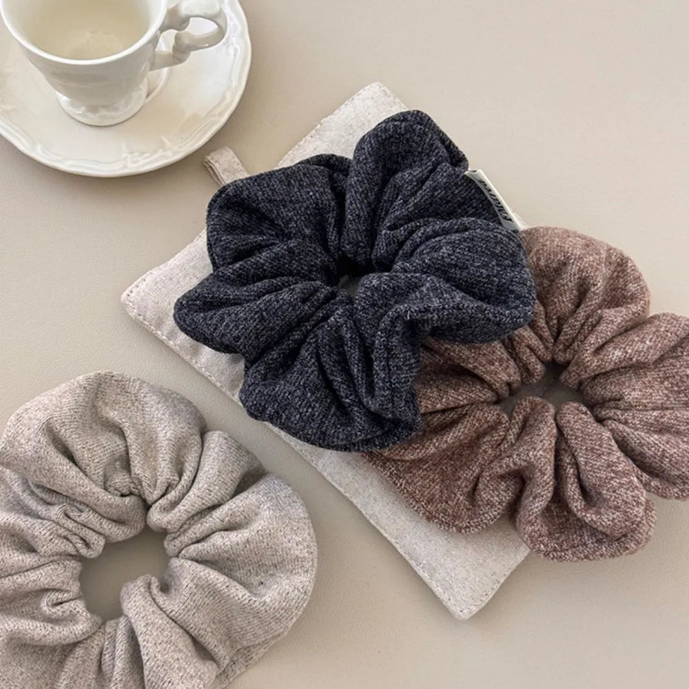 Textured knit scrunchie set in navy, taupe, and light grey.