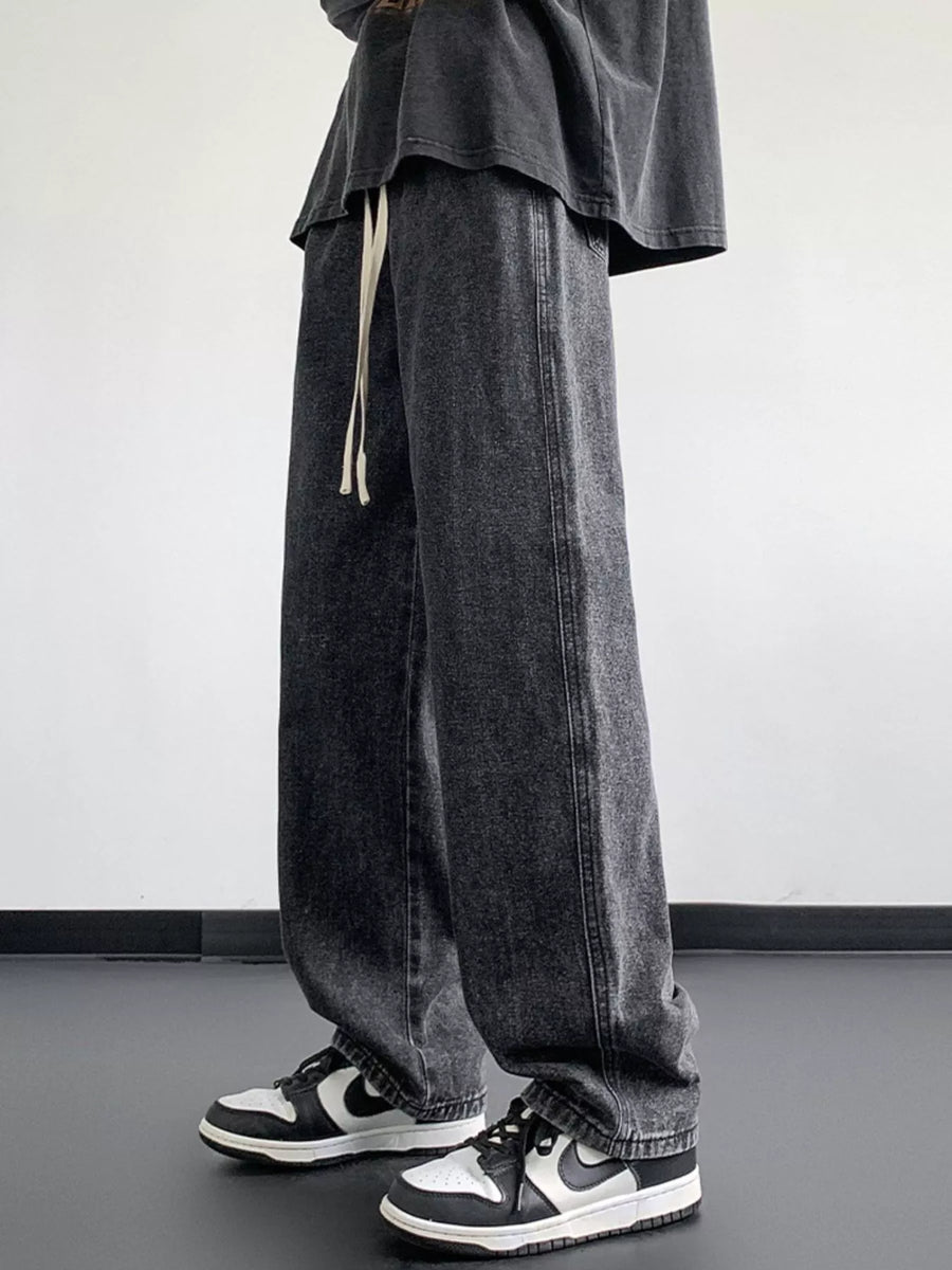Oversized drawstring jeans in dark gray wash with a loose fit and casual styling.