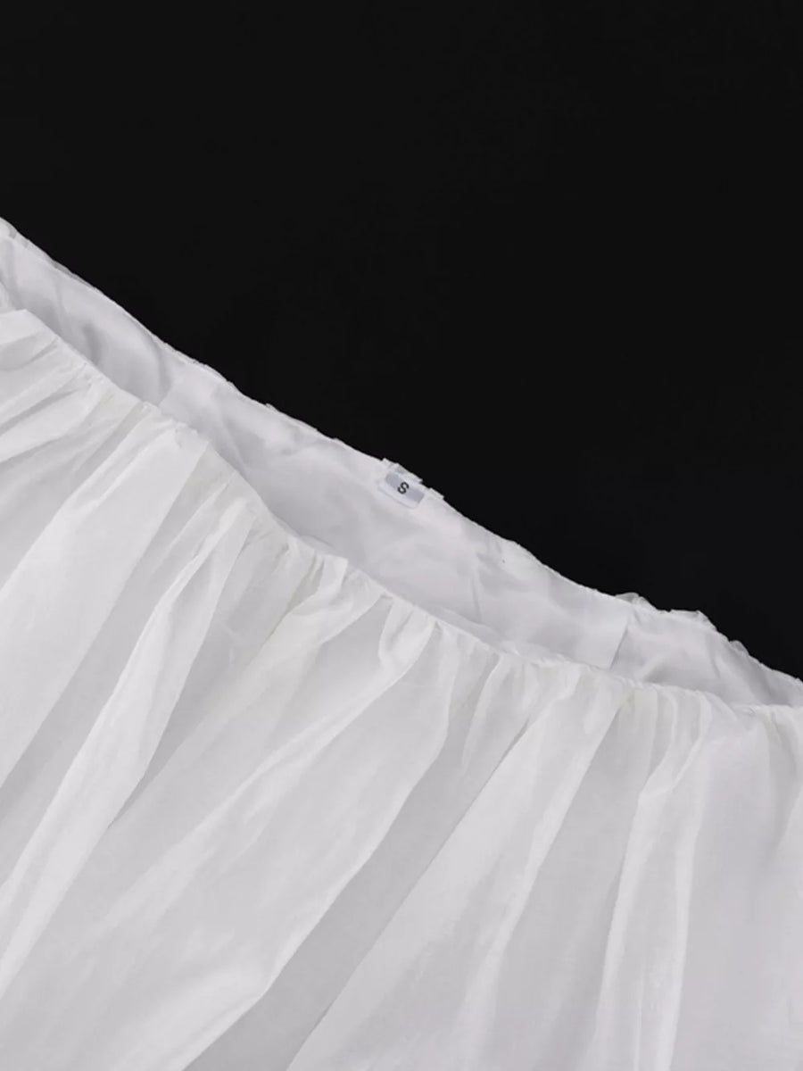 White crinoline petticoat with ruffled hem and elastic waistband.