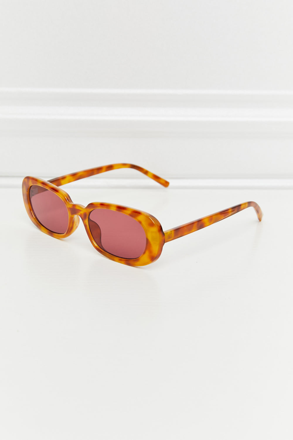 Tortoiseshell oval sunglasses with pink sunset lenses and a casual style.