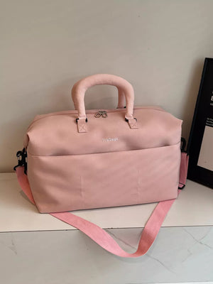 Pink duffel bag with top handles, front pocket, and adjustable strap.