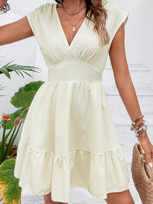 Tiered cap sleeve mini dress in white with a ruffled hem and V-neck.