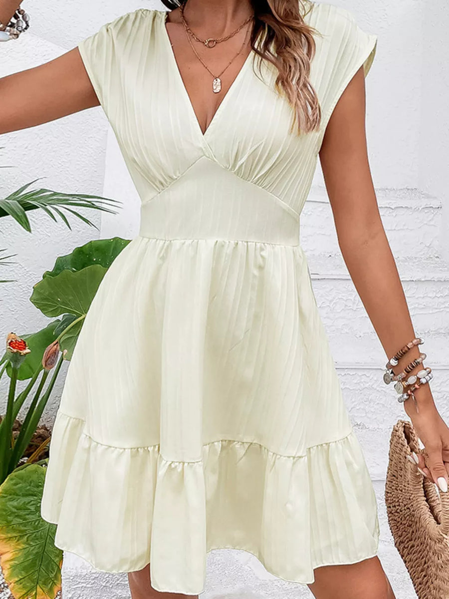 Tiered cap sleeve mini dress in white with a ruffled hem and V-neck.