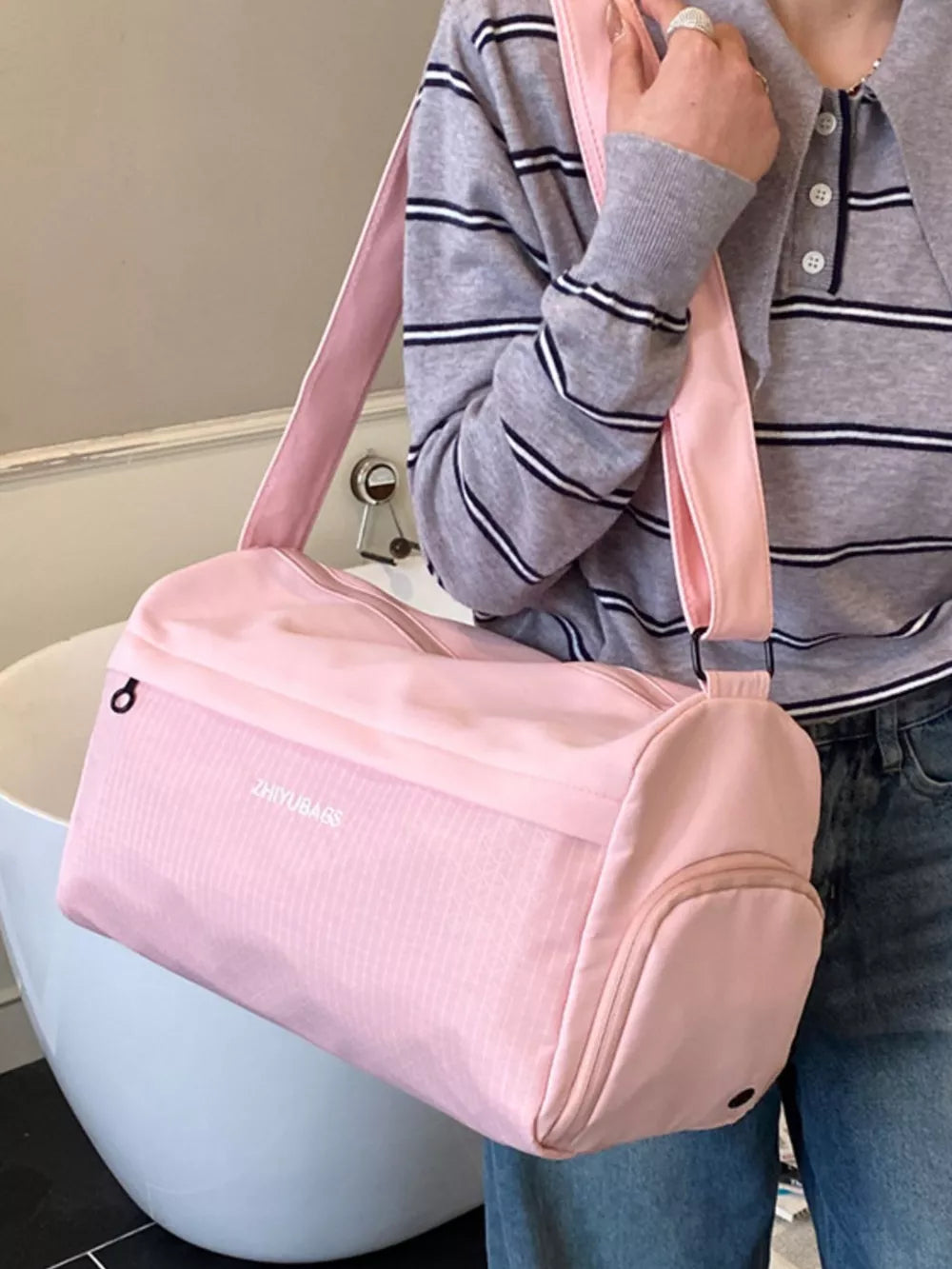 Pink travel organizer bag with textured panels and dual handles.