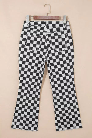 Checkerboard distressed cropped jeans in black and white denim with frayed hem.