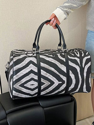 Large black and white zebra print duffle bag with carry handles and detachable strap