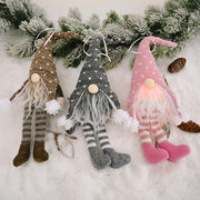 Knitted gnome ornaments in light gray, blush pink, and khaki with striped legs and pom-pom accents.
