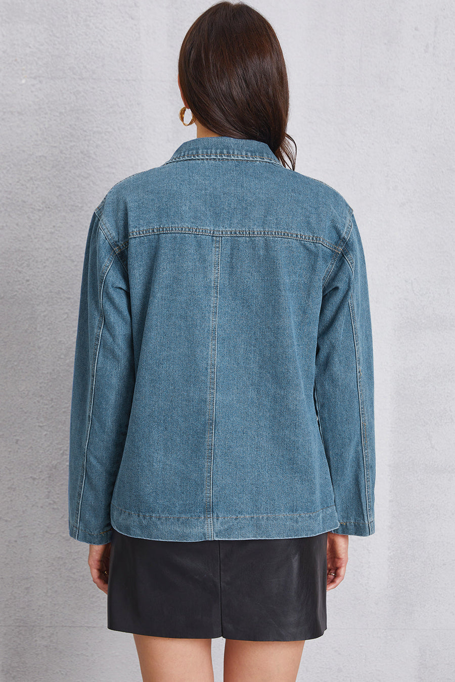 Denim blazer in medium wash with tailored seam detailing and button closure.