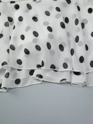 White polka dot mini dress with tiered ruffled hem detail.