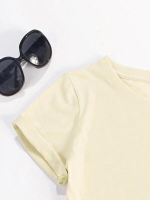 Cream t-shirt with rolled sleeves and a crew neck, styled with sunglasses.