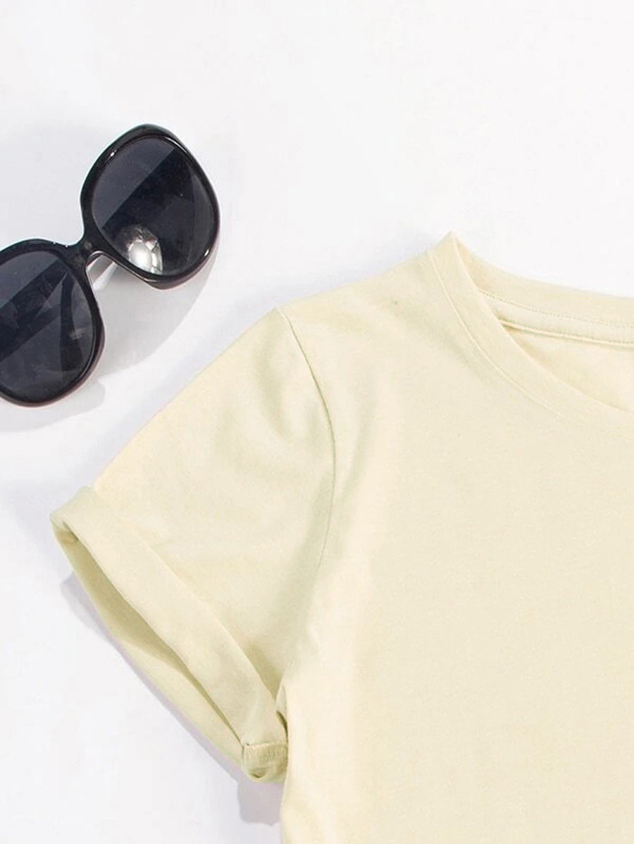 Cream t-shirt with rolled sleeves and a crew neck, styled with sunglasses.