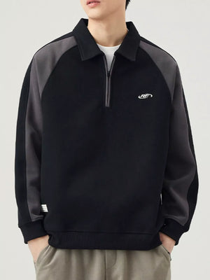 Black raglan quarter zip sweatshirt with contrast gray sleeves and embroidered logo.