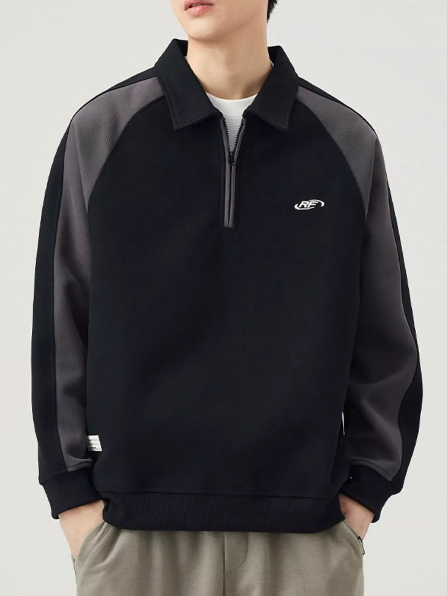 Black raglan quarter zip sweatshirt with contrast gray sleeves and embroidered logo.