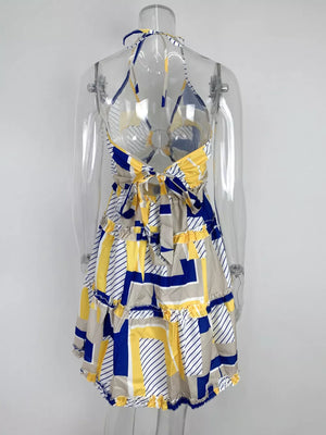 Abstract print halter mini dress with tiered ruffles and a tie back in yellow, blue, and tan.