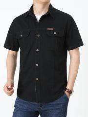 Men's black short sleeve cotton shirt with buttoned chest pockets and a small leather patch detail.