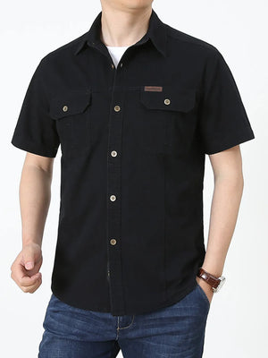 Men's black short sleeve cotton shirt with buttoned chest pockets and a small leather patch detail.