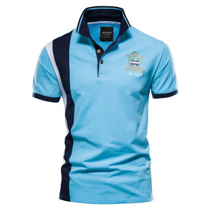 Colorblock polo shirt in sky blue with navy and white side panels and embroidered crest detail.