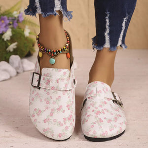Floral print slip-on flats in beige with a decorative buckle and adjustable strap.